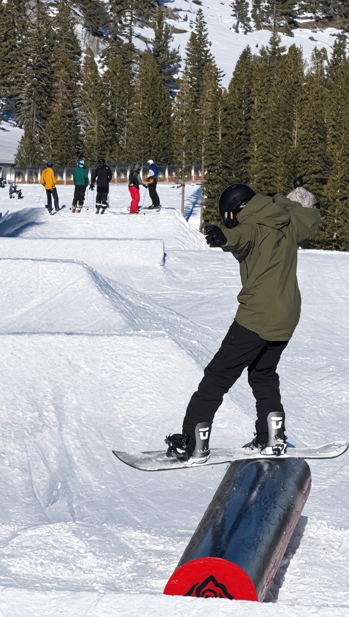 Sahishnu snowboarding across a box in a terrain park