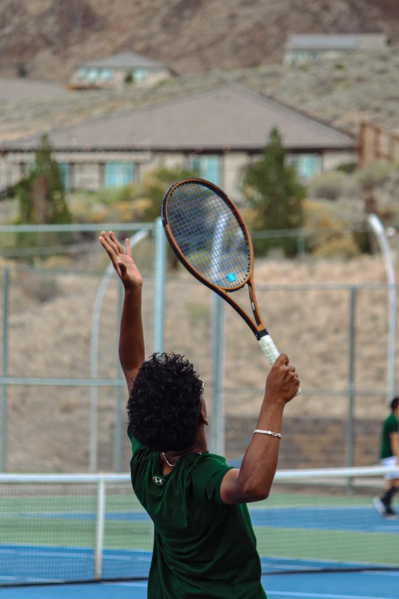 Sahishnu serving on an outdoor tennis court